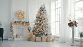 Christmas and New Year interior in light classic style. White room with Xmas Tree decorated, flashing garland, balls, fireplace and gifts. Bright New Year celebration décor. Winter Holiday Background - Powered by Shutterstock - Get 15% off with code: PIKWIZARD15