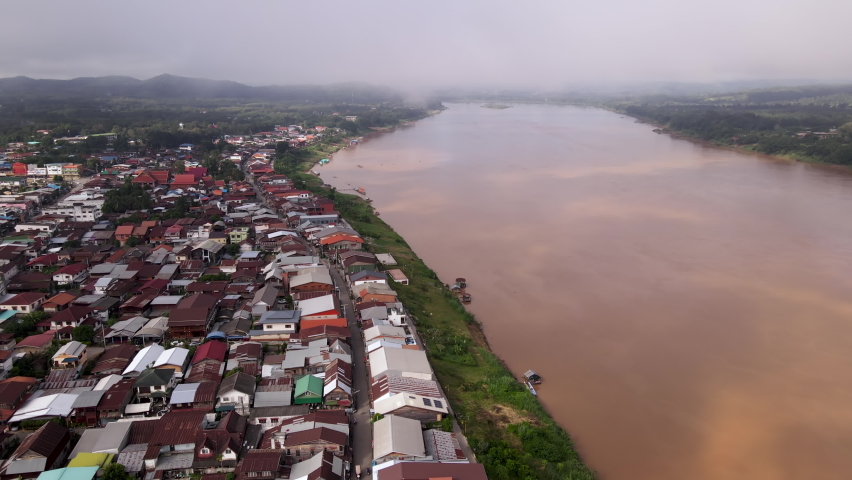 Aerial view tilt down over the Chiang Khan Old Village during misty morning, It is a village along the Mekong River which is now a famous tourist attraction of Loei Province Thailand.