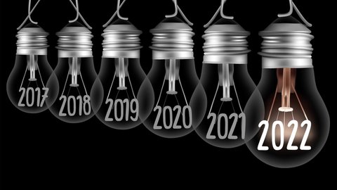 Shining light bulb with New Year 2022 and group of dark light bulbs in a row going from 2017 to 2021 isolated on black background. High quality 4k video.