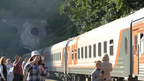 14.10.2010: New Athos, Abkhazia: The train passes by the station Psyrtskha, New Athos. Tourists take pictures on their phones