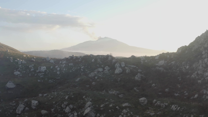 Aerial shot of the clouds over the megalithic complex of Argimusco in Sicily on the Nebrodi. Etna view and mystical scenery in Sicily. Sunset on the Argimusco Megaliths. Royalty-Free Stock Footage #1081871603