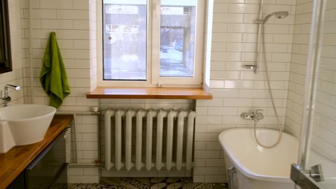 Bathroom interior with toilet bowl, mirror with bathtub sink and shower cabin with window and heating radiator
