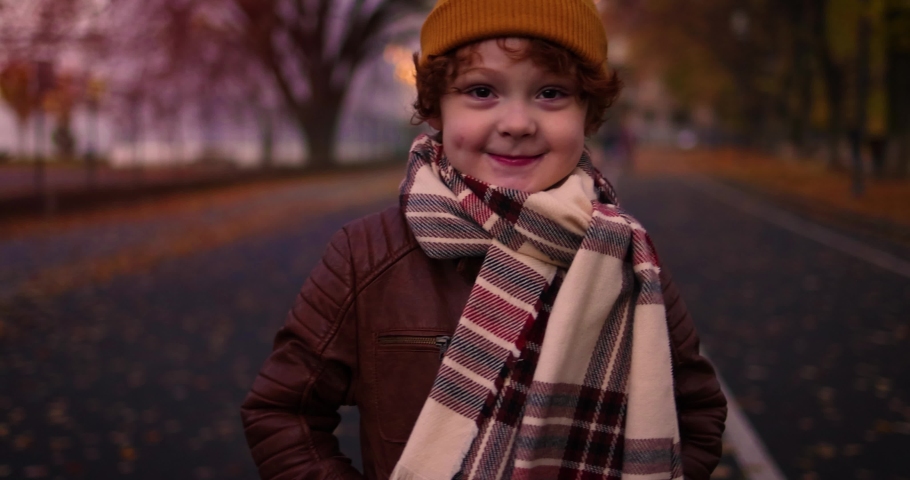 handsome redhead kid, young boy on a walk in autumn city