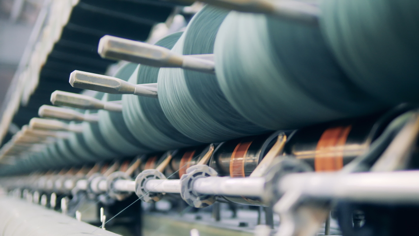 Sewing spools managed by a factory machine in a close up Royalty-Free Stock Footage #1081876547