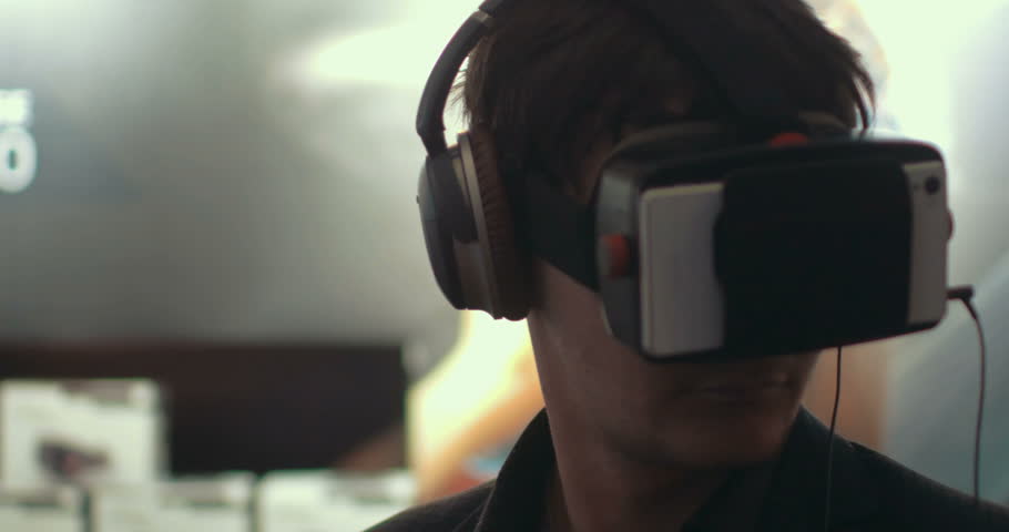 Close-up shot of a man in headphones getting experience in using VR-headset. Augmented reality device creating virtual space for smartphone applications Royalty-Free Stock Footage #10818800