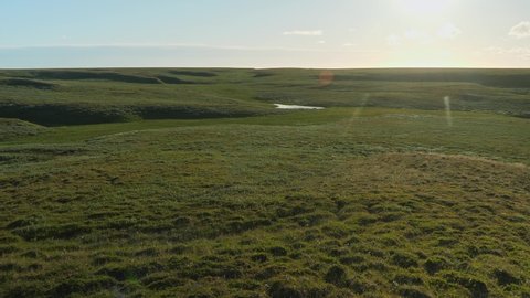 Panoramic view of grass and water system on Yamal peninsula. Lens flare. Wild nature of Russia.