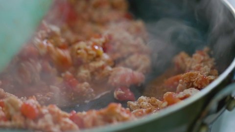 Process of frying minced meat for making Mexican tacos. Frying and stirring mince meat. Stirring minced chicken with a silicone spatula. Mexican cuisine