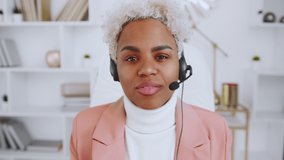 Headshot screen view portrait of confident millennial African American female employee in headset talk on video call in office. Young ethnic business woman have webcam virtual conference online.