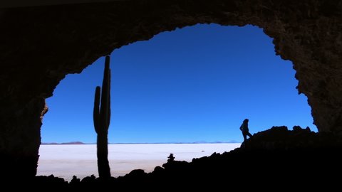Woman explores the cave on the island at Salar de Uyuni salt flat in Bolivia
