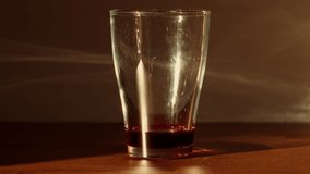 Sparkling water getting poured into a glass with red syrup in golden sunlight. As the water gets poured in, many swirls occur in the glass and gas bubbles rise to the top. - Powered by Shutterstock - Get 15% off with code: PIKWIZARD15