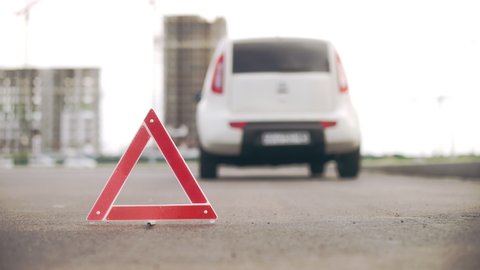 Warning triangle on road, broken car, malfunction, driver waiting for tow truck