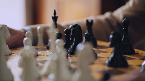 Male hand moving chess figure on wooden board, winning strategy, capture