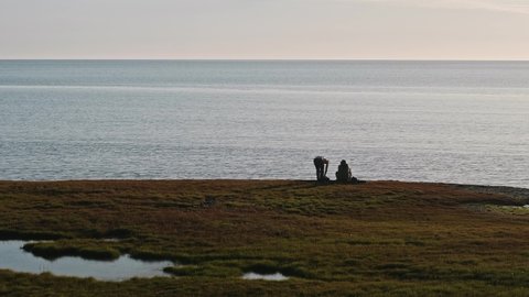 Two hydrologists wearing antimosquito screens on their heads examine ground and make measures. Descover Yamal peninsula.