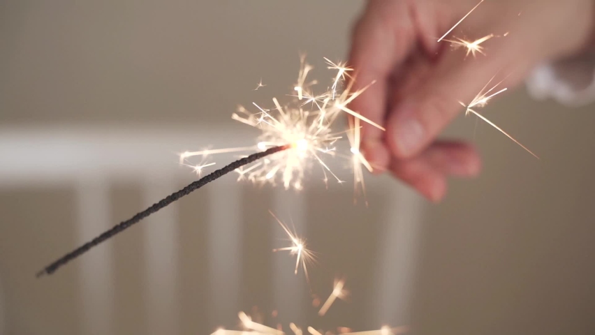 Slow motion two cheerful women with sparklers for Christmas with glasses of champagne and lights on the background. Happy new year. Christmas night. Happy family and celebrate