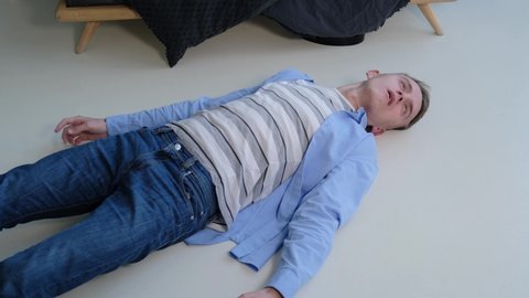 Epileptic seizure. A man struggles in convulsions while lying on the floor