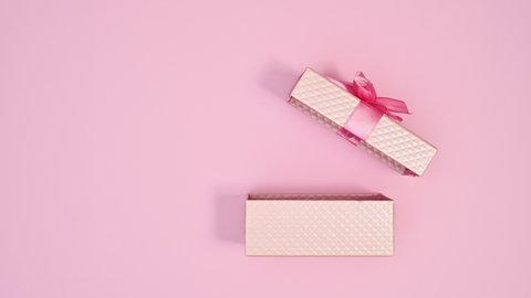 6k Pastel pink gift with pink ribbon appear and open on pastel pink theme. Stop motion