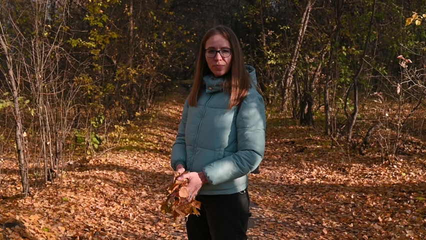Beautiful autumn woman throws up autumn leaves. Walk in the autumn forest, Slowmo