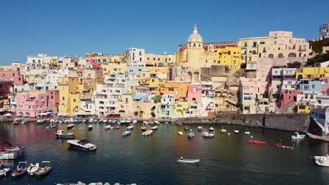 Aerial drone footage of the Procida typyical old town with its fisherman harbor in the bay of Napoli in Italy. Shot with a sliding motion. 