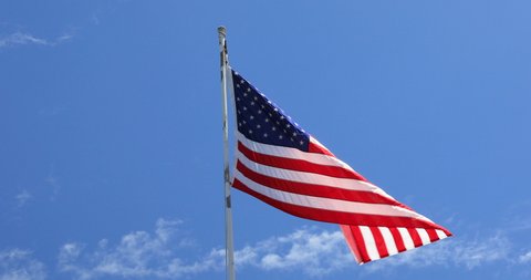 Stationary handheld footage of Americain flag blowing in the wind with blue sky background,Hawaii,USA