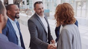 Happy mature African businessman shaking hands with businesswoman in modern office. Successful african american entrepreneur greeting business woman with handshake. Agreement and business deal concept - Powered by Shutterstock - Get 15% off with code: PIKWIZARD15