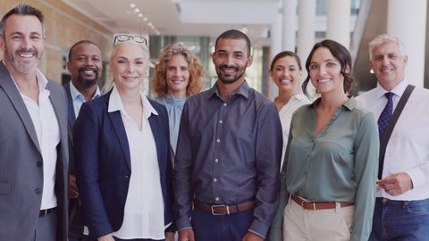 Group of happy multiethnic business people smiling and showing sign of success. Successful business team showing thumbs up and looking at camera. Portrait of proud businessmen and businesswomen.