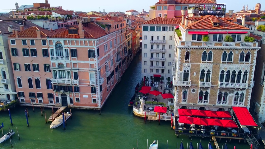 Aerial view of the city on the water and rooftops, the bell tower of the basilica and the unique canals with boats, crossing Venice and Italy. Gondolas with tourists. Carnival and Film Festival. Masks Royalty-Free Stock Footage #1081987349