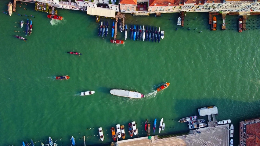 Aerial view of the city on the water and rooftops, the bell tower of the basilica and the unique canals with boats, crossing Venice and Italy. Gondolas with tourists. Carnival and Film Festival. Masks