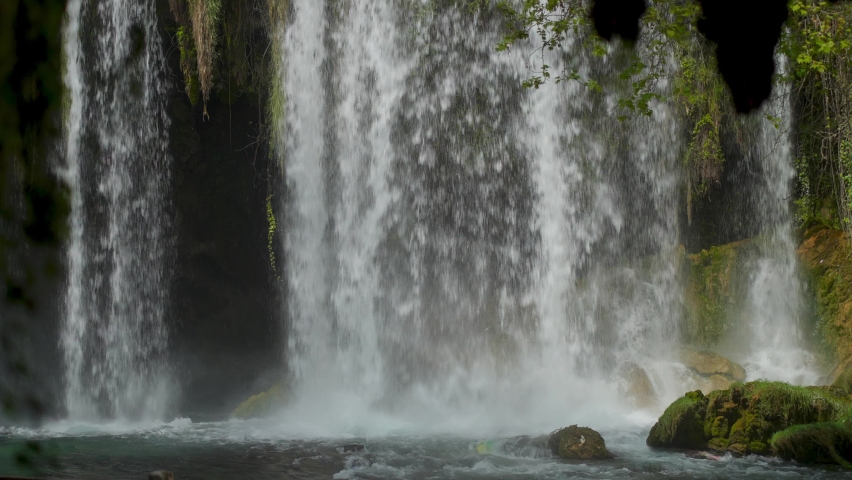 slow motion of Upper Duden Waterfall in Antalya, Turkey. grandiose powerful streams of water flows fron high steep cliff in big cave