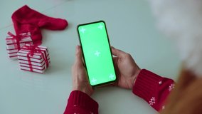 Green screen pnone in hands. Christmas time - Powered by Shutterstock - Get 15% off with code: PIKWIZARD15