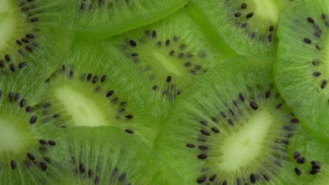 Juicy green kiwi fruit or chinese gooseberry, background in the form of sliced kiwi spins