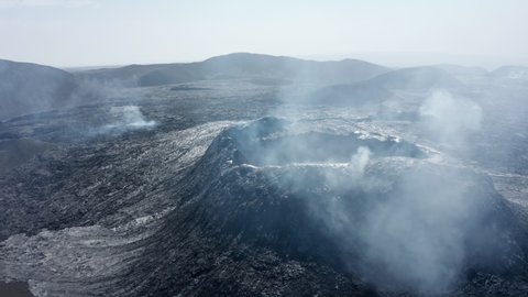 Fly above volcanic landscape after eruption. Aerial view of smoke coming from volcano. Fagradalsfjall volcano. Iceland, 2021