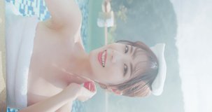 vertical video of asian young woman putting towel on head live stream while she relaxing sitting in hot spring