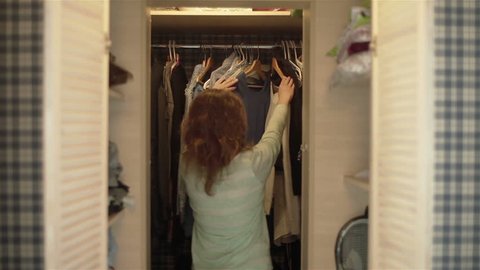 Attractive young women choosing clothes in wardrobe preparing to go out