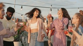 Group of joyful young people listening favorite music and dancing on rooftop. Multicultural friends in stylish outfit hanging out together. Summer party with fun. - Powered by Shutterstock - Get 15% off with code: PIKWIZARD15
