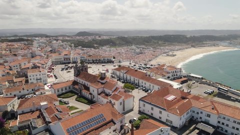 Sítio da Nazaré overlooking amazing beach and resort town, Portugal. Aerial forward view