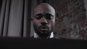 African American works for a laptop, talks by video link. Black business man works remotely. Face close up