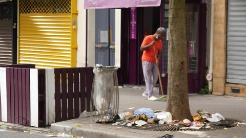 PARIS, FRANCE - OCTOBER 30, 2021: A Black Man cleans on a Street near his Restaurant in Paris