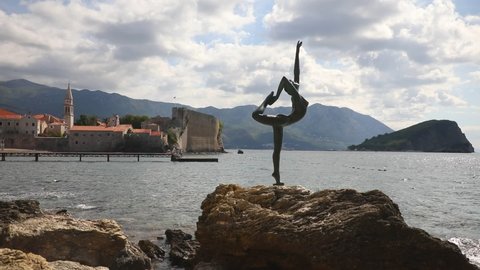 Budva, Montenegro - September 18, 2021: Statue of a dancer on the background of old town Budva, Montenegro. High quality photo
