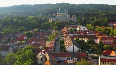 Drone shot flying over the town in front of the Castle Of Spirits or Bojnice Castle in Slovakia