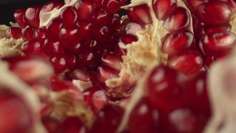 Beautiful pomegranate fruits for juice preparation. The benefits of drinking pomegranate juice for anemia. Pieces of pomegranate, close-up. High quality. 4k footage.
