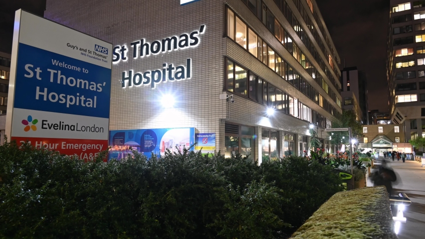 LONDON - NOVEMBER 3, 2021: MOTION TIMELAPSE PANNING shot of an entrance to St Thomas' Hospital at night