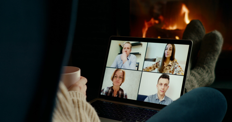 Online Group Video Call Conference of Work Team Meeting or Friends from Home Office Laptop at Fireplace in Winter Night. Self-isolation at COVID-19 Pandemic. 4K close up pan Shot Royalty-Free Stock Footage #1082054468