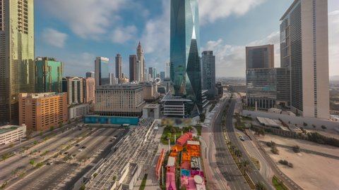 Dubai International Financial district aerial timelapse during all day with shadows moving fast. Panoramic view of business and financial office towers. Skyscrapers with big parking lot and shopping