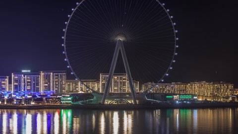 Bluewaters island with modern architecture and ferris wheel aerial night timelapse. New leisure and residential area near Dubai marina and JBR. Lights turning off