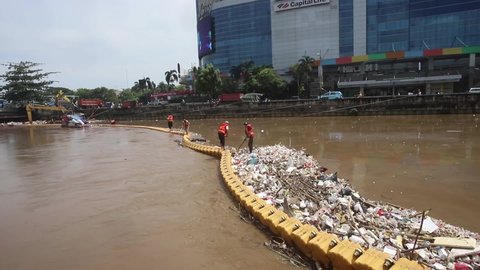 JAKARTA, INDONESIA - NOVEMBER 2021 - A number of workers from the Water Resources Service (SDA) clean up flooded garbage stuck in the pontoon on 10, November 2021 in Jakarta.