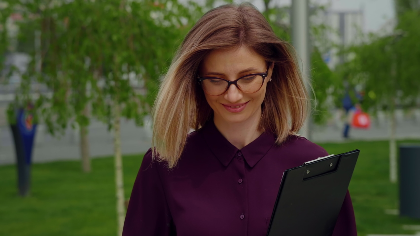 Happy Businesswoman walking out of Business building. Succesful woman expression.