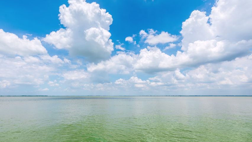 White clouds constantly changing shape in the blue sky.Blue sky and white clouds with lake water landscape.