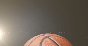 Animation of glowing gold particles moving over basketball. sport and competition concept, digitally generated video.