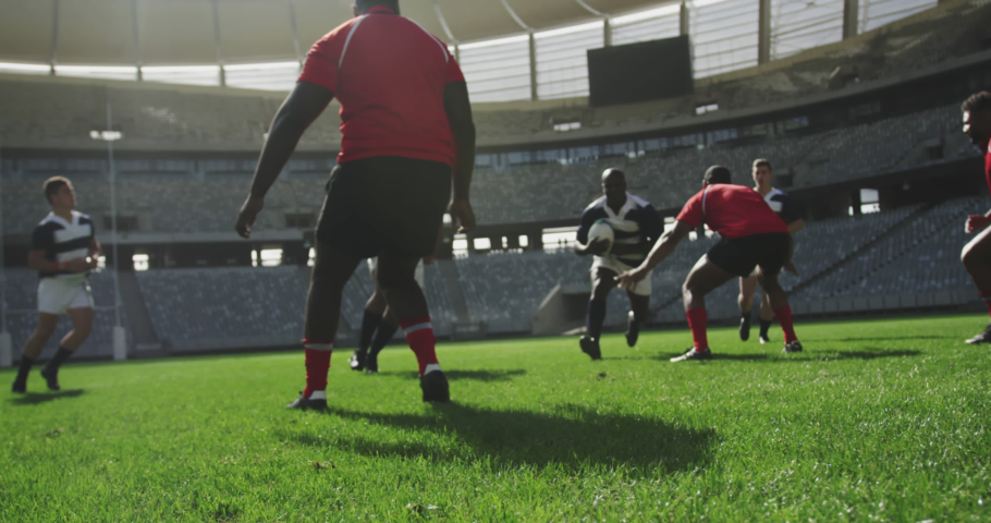 Animation of red line spiral rotating over male rugby players during match. sport and competition concept, digitally generated video.