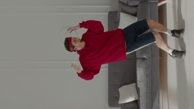 PHONE CAMERA POV, Vertical video. Caucasian teenager recording trendy dance moves for his social media account at home